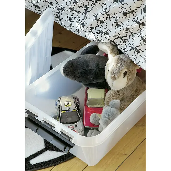 SmartStore Aufbewahrungsbox Classic 30 - L x B x H: 72 x 40 x 20 cm, Kunststoff, Transparent - Ein durchsichtiger Kunststoffbehälter, der mit Spielzeugautos und Stofftieren gefüllt ist, unter einem Bett mit Ameisenmuster.