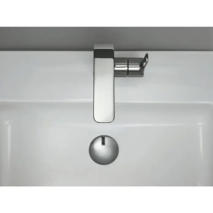 Grohe Lineare Waschtischarmatur L-Size - Chrom, Glänzend - Nahaufnahme eines modernen Waschbeckens mit einem eleganten Chromhahn und einem runden Abflussstopfen. Das Waschbecken ist aus weißer Keramik.