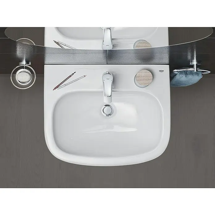 Grohe Eurosmart Waschtischarmatur M-Size - Mit Zugstange, Chrom, Glänzend - Das Bild zeigt ein Aufsichtsfoto von einem strahlend weißen Waschbecken mit Armatur, das in einem modernen Badezimmer installiert ist.