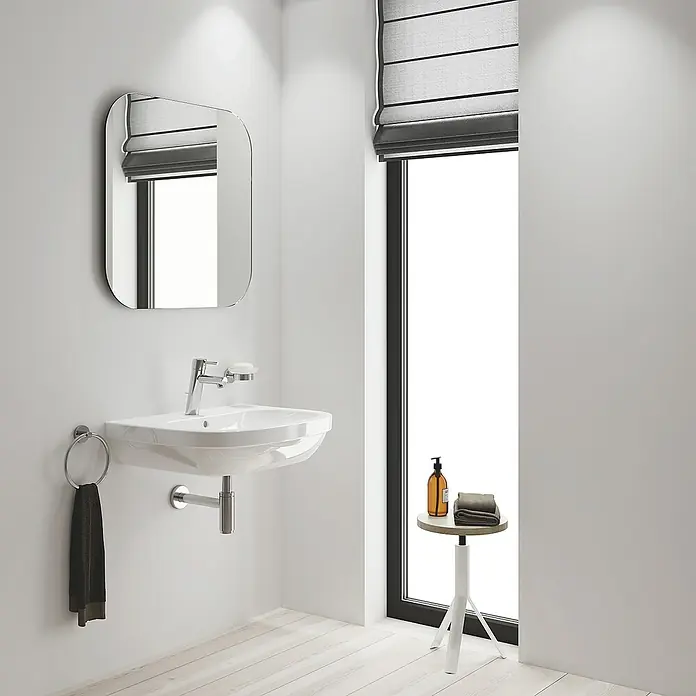 Grohe Concetto Waschtischarmatur M-Size - Mit Zugstange, Chrom, Glänzend - Das Bild zeigt ein modernes Badezimmer mit einem weißen Waschbecken, einem Spiegel und einem kleinen Beistelltisch.