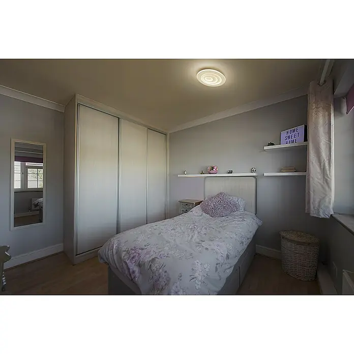Ledvance Orbis LED-Deckenleuchte rund Spiral - 38 W, Ø x H: 36,5 x 5,6 cm, Weiß, Warmweiß - Helles Schlafzimmer mit einem Einzelbett, einem großen Kleiderschrank mit Schiebetüren und sanften Grautönen, die eine ruhige, entspannende Atmosphäre schaffen.