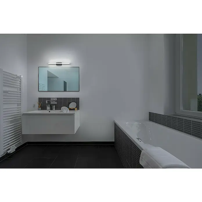 Ledvance Orbis LED-Spiegelleuchte Mirror - 10 W, L x B x H: 60 x 8,8 x 5,7 cm, Schwarz, Warmweiß - Elegantes Badezimmer mit stilvollem Waschbeckenunterschrank, großem Spiegel mit LED-Leuchte und Badewanne. Moderne Fliesen und dunkler Boden ergänzen das Design.