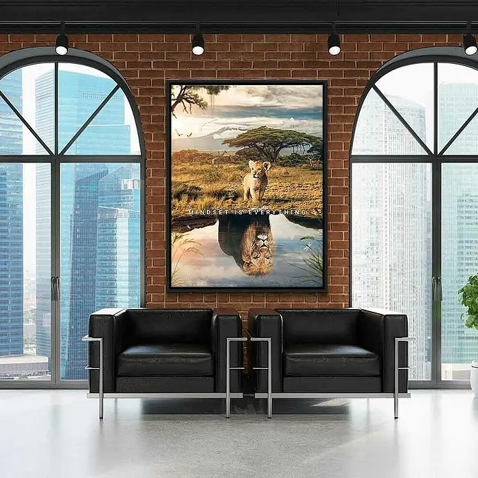 Dotcomcanvas Leinwandbild - Mindset Is Everything Africa, B x H: 75 x 100 cm - Ein gerahmtes Löwen-Wandbild mit der Aufschrift "Mindset is Everything" hängt über zwei modernen schwarzen Sesseln in einem stilvollen Wohnraum.