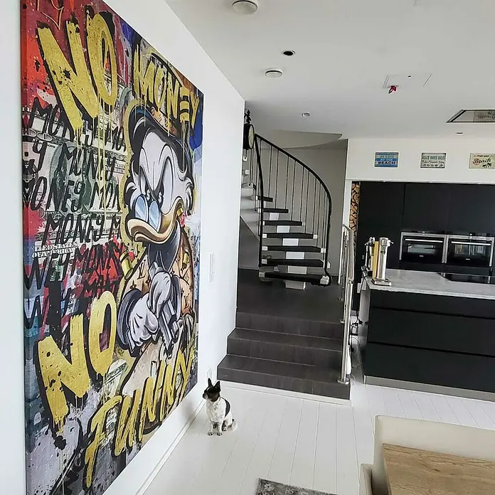 Dotcomcanvas Leinwandbild - No Money Duck, B x H: 90 x 120 cm - Großes Wandbild mit Donald Duck und Graffiti-Schriftzug "No Money No Funny" neben einer Treppe in einem modernen Haus.
