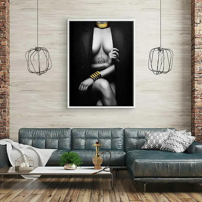 Dotcomcanvas Leinwandbild - Elegant Pose, B x H: 75 x 100 cm - Elegantes Wandbild: Schwarz-Weiß-Fotografie einer Frau mit goldenem Schmuck, gerahmt in Weiß, über einem stilvollen blauen Ledersofa.