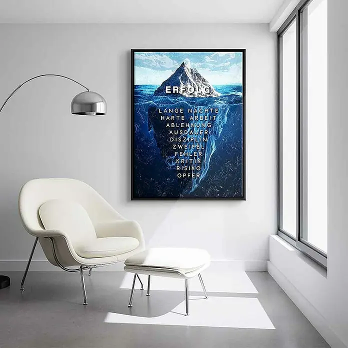 Dotcomcanvas Leinwandbild - Eisberg des Erfolgs, B x H: 90 x 120 cm - Das Bild zeigt ein gerahmtes Poster mit einem Eisberg, dessen Spitze mit "ERFOLG" beschriftet ist, daneben ein eleganter Sessel und eine Stehlampe.
