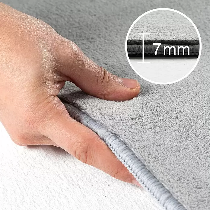 Kurzflorteppich Sky - Silber, Durchmesser: 120 cm, 100 % Polyester - Weiche graue Badematte, eine Hand demonstriert die Plüschtextur. Die Einblendung zeigt 7 mm Dicke.