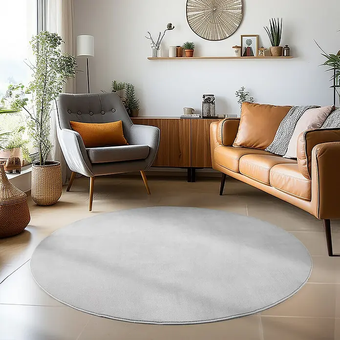 Kurzflorteppich Sky - Silber, Durchmesser: 120 cm, 100 % Polyester - Ein stilvolles Wohnzimmer mit einem hellgrauen, runden Teppich, der perfekt zum Interieur passt. Sorgt für Wärme und Komfort.