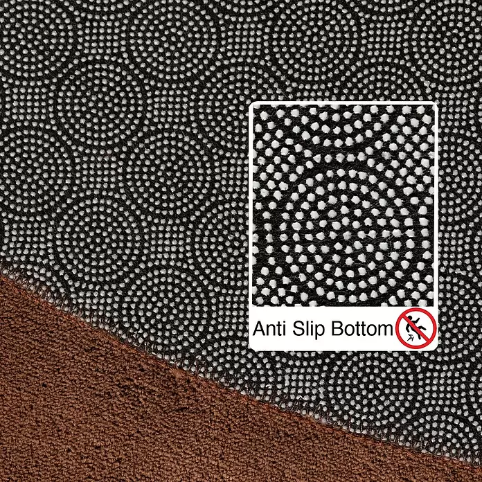 Kurzflorteppich Sky - Braun, Durchmesser: 120 cm, 100 % Polyester - Nahaufnahme der schwarzen Anti-Rutsch-Unterseite eines braunen Teppichs mit weißen Punkten.