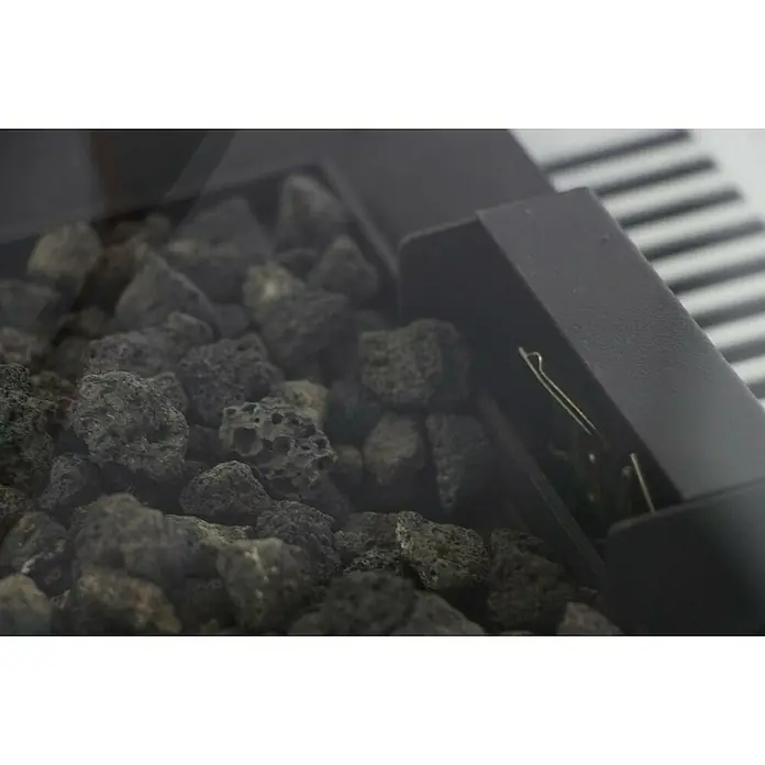 Nora Flames Estufa de exterior Aspro - 8 kW, Altura: 155 cm - Primer plano de rocas de lava en un brasero negro, agregando un toque atmosférico a su espacio exterior.