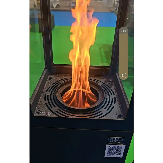 Nora Flames Estufa de pellets de exterior Ilios - 5 kW, Altura: 142 cm, Antracita - Primer plano de una estufa Nora Flames con un fuego brillante y danzante que irradia calidez y ambiente.