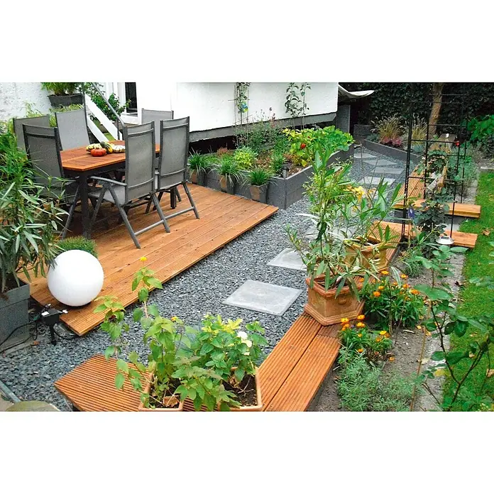 Min2C Schieferplättchen - Schwarz, Körnung: 22 mm - 40 mm, 20 kg - Bild eines Außenbereichs mit Terrasse, Sitzmöbeln und üppiger Bepflanzung, die eine harmonische Gartenatmosphäre schafft.