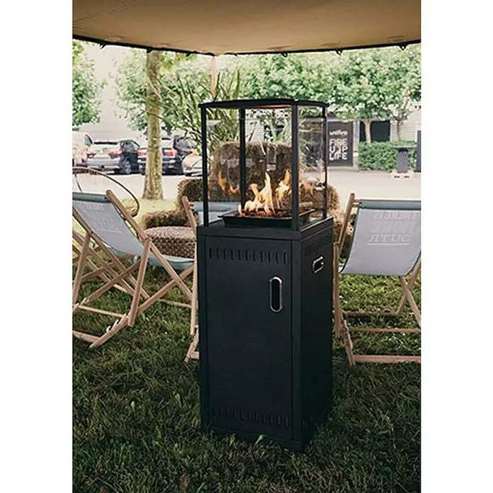 Outr Estufa de exterior Ibiza - 9 kW, Altura: 134,5 cm - Estufa de patio negra elegante con vidrio y llamas visibles, rodeada de sillas y vegetación.