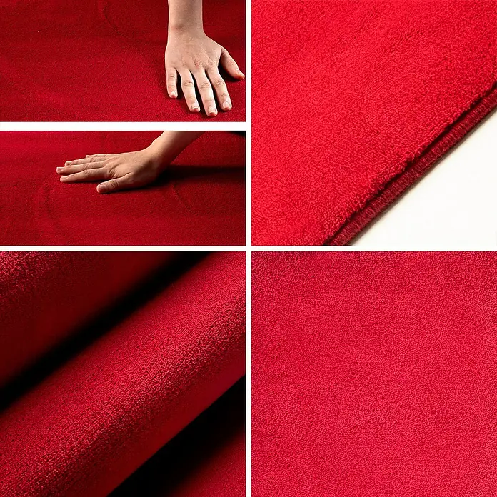 Kurzflorteppich Sky - Rot, Durchmesser: 120 cm, 100 % Polyester - Roter Teppich aus nächster Nähe mit Hand, um die Textur und Weichheit des Materials zu demonstrieren.