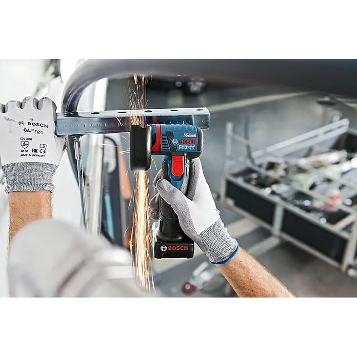 Bosch Professional Akku-Winkelschleifer GWS 12V-76 L-Boxx - Ohne Akku, Durchmesser Scheibe: 76 mm, 19.500 U/min - Eine Person benutzt einen blauen Bosch Professional Akku-Winkelschleifer mit Funkenflug zum Schneiden eines Metallstücks.