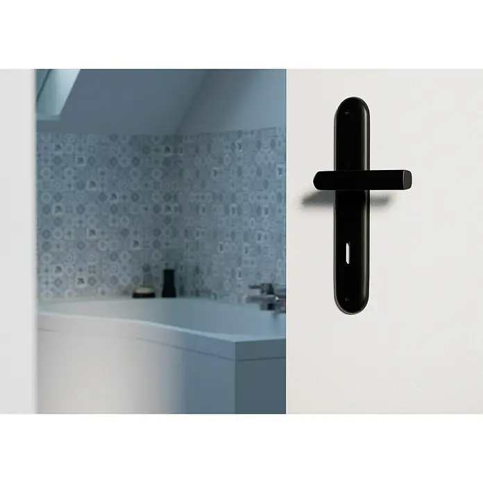 Hoppe Zimmertürgarnitur HamburgStärke Tür: 42 mm - 37 mm, Aluminium, Buntbart - Schwarzer Türgriff mit länglicher Rosette an einer weißen Tür, im Hintergrund ein Badezimmer mit Badewanne und Mosaikwand.
