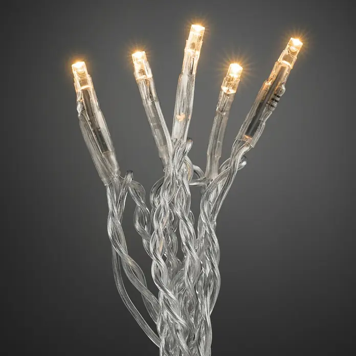Konstsmide LED-Lichterkette - Innen, Lichtfarbe: Warmweiß, Anzahl Leuchtmittel: 35 Stk., Netzbetrieben, Transparent - Nahaufnahme von leuchtenden LED-Lichterketten mit transparentem Kabel vor einem grauen Hintergrund, ideal für stimmungsvolle Dekorationen.