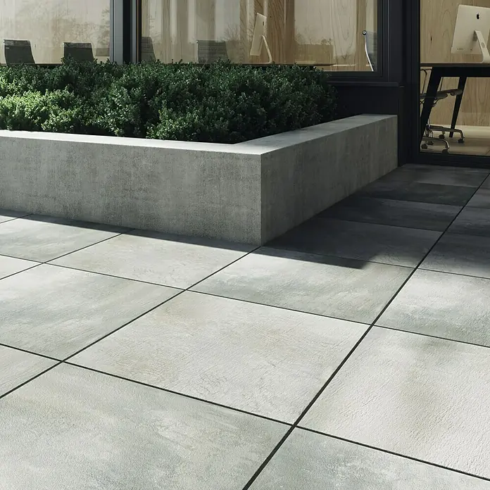 Cersanit Terrassenfliese Beton Grey Light - 59,3 x 59,3 x 2 cm, Grau, Matt - Die grauen Terrassenplatten bilden einen modernen Außenbereich. Der erhöhte Pflanzkasten mit Grünpflanzen ergänzt das Design.