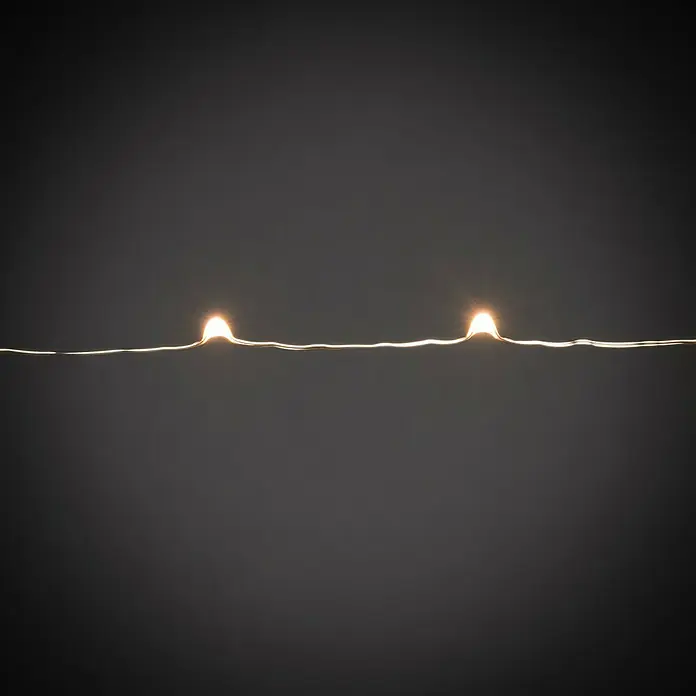 Konstsmide LED-Lichterkette Baummantel - Innen, Lichtfarbe: Bernstein, Anzahl Leuchtmittel: 240 Stk., Netzbetrieben - Nahaufnahme einer Lichterkette mit warmweißen LEDs, die eine gemütliche Atmosphäre schaffen. Perfekt für festliche Dekorationen und stimmungsvolle Beleuchtung.
