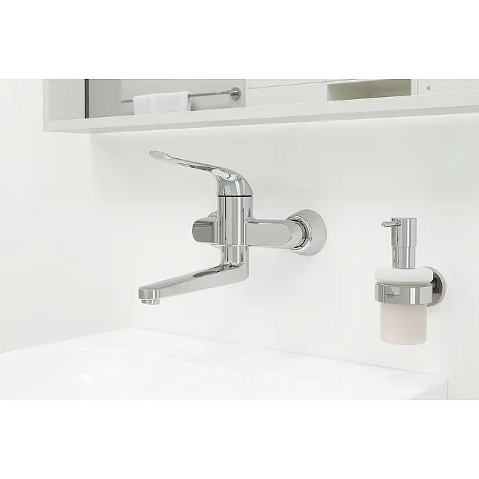 Grohe Euroeco Special Waschtischarmatur - Wandmontage, Chrom, Glänzend, Ausladung Armatur: 341 mm - Einbau-Waschtischarmatur von Grohe mit Seifenspender in einem modernen Badezimmer. Die Armatur ist aus glänzendem Chrom gefertigt.