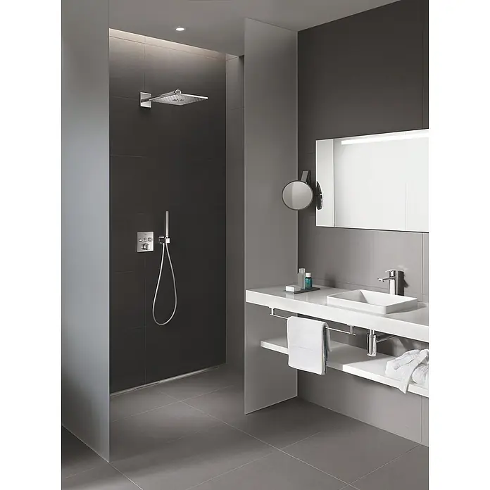Grohe Lineare Waschtischarmatur S-Size - Mit Zugstange, Chrom - Elegantes Badezimmer mit grauen Fliesen, einer modernen Dusche mit Kopfbrause und einer Waschtischkombination mit Spiegel.