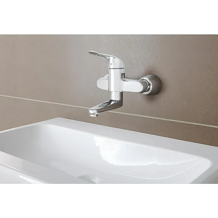 Grohe Euroeco Special Waschtischarmatur - Wandmontage, Chrom, Glänzend, Ausladung Armatur: 214 mm, Mit absperrbaren S-Anschlüssen - Nahaufnahme einer modernen, verchromten Wandarmatur über einem eleganten, weißen Waschbecken. Stilvolles Design für jedes Badezimmer.