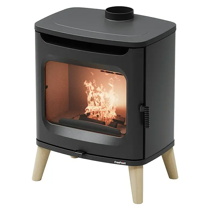 FreePoint Estufa de leña Flos Wood - 7 kW, Volumen de calefacción: 196 m³, Negro - Primer plano de una estufa de leña negra FreePoint con ventana de cristal y leña ardiendo, sobre patas de madera clara.