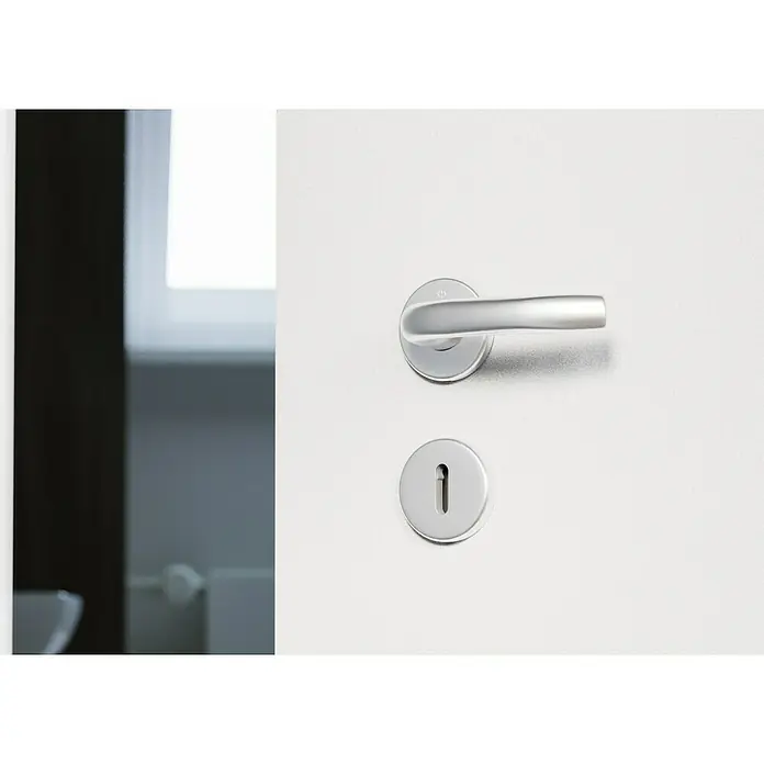 Hoppe Drückergarnitur TokyoStärke Tür: 42 mm - 37 mm, Aluminium, Buntbart, Form Schild: Rund - Nahaufnahme einer modernen, silbernen Türklinke und einem Schlüsselloch auf einer weißen Tür. Elegantes Design für ein stilvolles Zuhause.