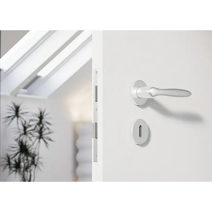 Hoppe Zimmertürgarnitur Verona - Stärke Tür: 42 mm - 37 mm, Aluminium, Buntbart - Nahaufnahme einer modernen, weißen Innentür mit einem eleganten, silbernen Türgriff und Schloss. Das Design ist minimalistisch.
