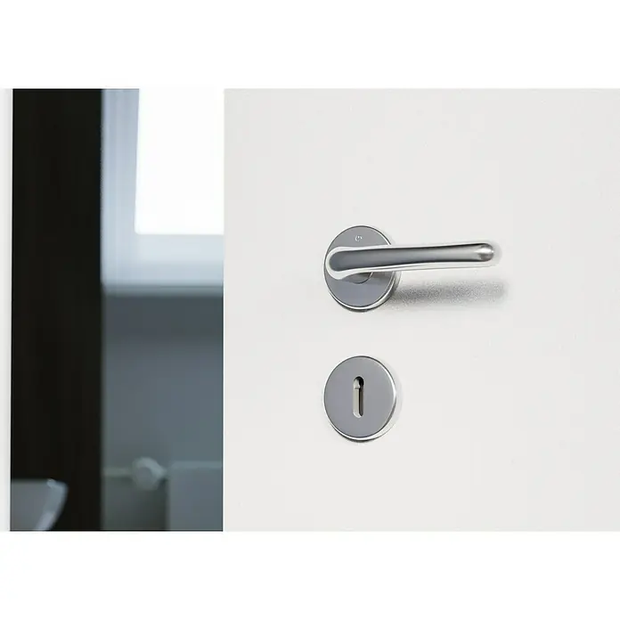 Hoppe Drückergarnitur Cardiff - Stärke Tür: 42 mm - 37 mm, Edelstahl, Buntbart, Form Schild: Rund - Nahaufnahme einer modernen Tür mit silbernem Türgriff und Schlüsselloch auf einer weißen Tür.