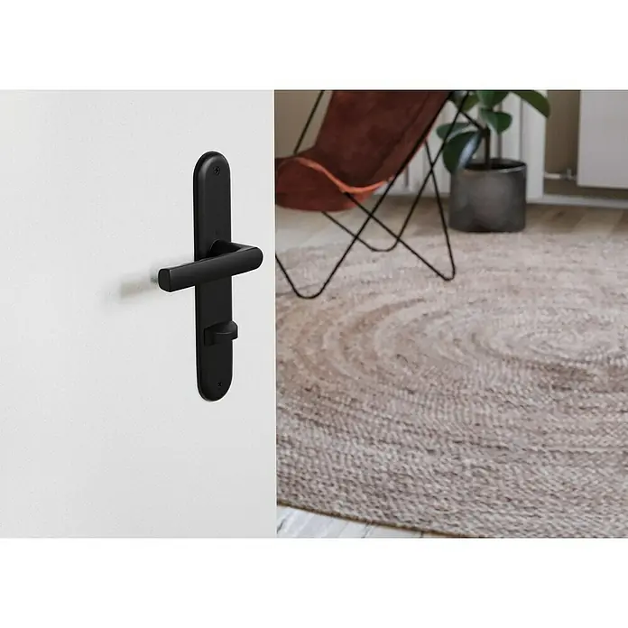 Hoppe Zimmertürgarnitur WC Hamburg - Stärke Tür: 42 mm - 37 mm, Aluminium, Schlitzkopf/Olive - Nahaufnahme eines modernen schwarzen Türgriffs mit Schloss an einer weißen Tür, der ein elegantes und minimalistisches Design aufweist.