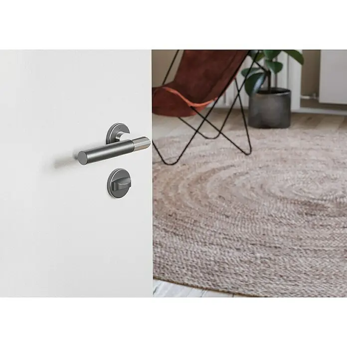 Hoppe Zimmertürgarnitur WC Lecce - Stärke Tür: 42 mm - 37 mm, Aluminium, Schlitzkopf/Olive - Nahaufnahme eines modernen Türgriffs aus gebürstetem Metall auf einer weißen Tür, der Design und Funktionalität vereint.