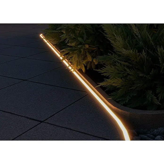Starlux LED-Lichtschlauch - 5 m, 6 W, Warmweiß - Außenaufnahme eines LED-Streifens, der neben grünen Pflanzen auf einer Pflasterfläche verläuft und eine warme, einladende Atmosphäre schafft.