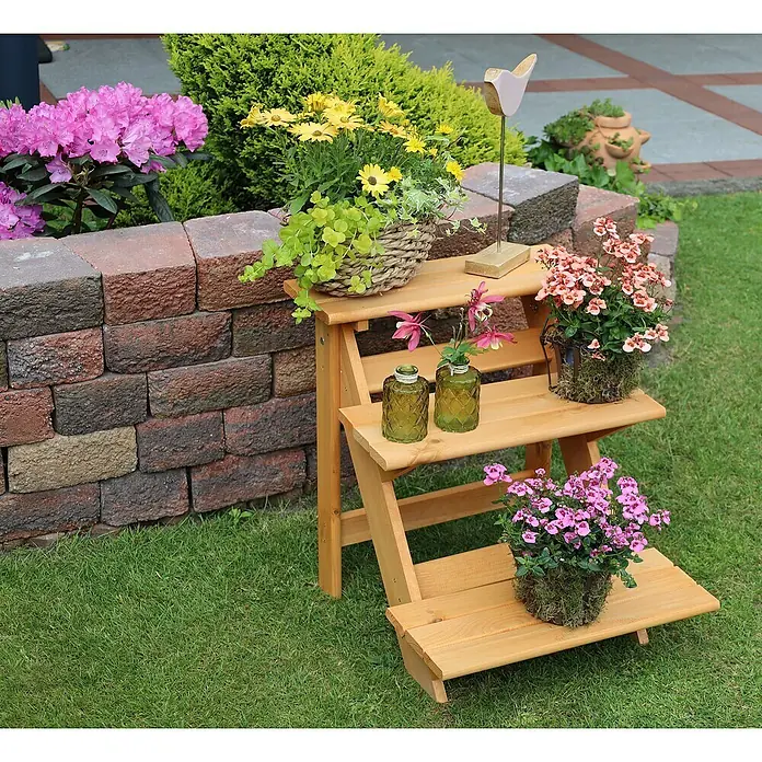 Promadino Blumentreppe - 60 x 50 x 56 cm, Kiefer, Braun - Eine dreistufige Pflanzentreppe aus Holz, geschmückt mit bunten Blumen und dekorativen Glasvasen, die eine idyllische Gartenszene schafft.