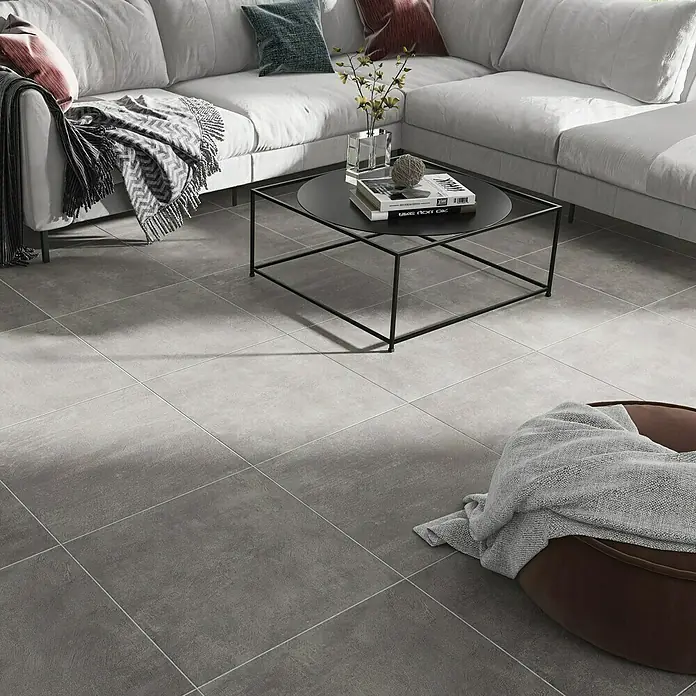 Marazzi Feinsteinzeugfliese Boston - 60 x 60 cm, Anthrazit, Matt - Bild eines modernen Wohnzimmers mit grauen Bodenfliesen, die ein elegantes und zeitgemäßes Ambiente schaffen. Die Fliesen sind quadratisch und matt.