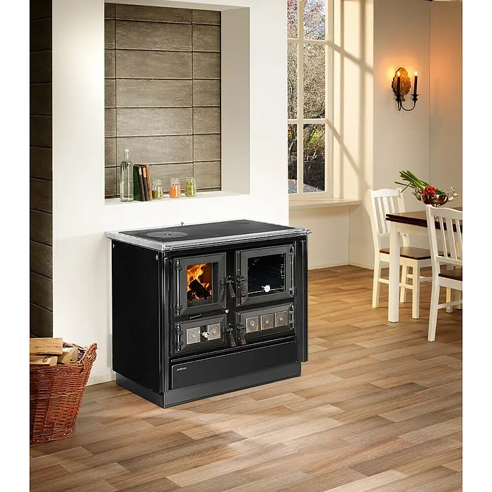 Justus Küchenherd Rustico-90 2.0 - 7 kW, Raumheizvermögen: 144 m³, Backofen rechts, Schwarz - Ein detailreiches Bild zeigt einen eleganten, schwarzen Küchenherd mit sichtbarem Feuer und Ofen, umgeben von einem gemütlichen Interieur.