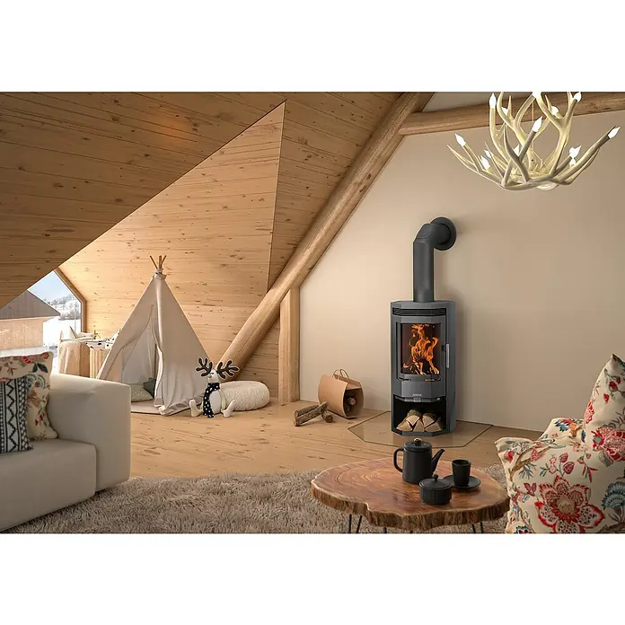 Justus Kaminofen Usedom 5 D - 5,5 kW, Raumheizvermögen: 88 m³, Material Verkleidung: Stahl, Gussgrau - Gemütliches Wohnzimmer mit einem Kaminofen, der Wärme und Atmosphäre spendet. Der Ofen ist ein zentrales Element des Raumes.