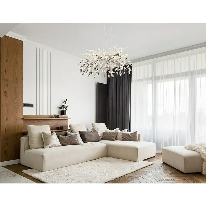 Globo Hängelampe Danna - 8 W, Ø x H: 61 x 120 cm, Chrom/Rauchfarben - Elegantes Wohnzimmer mit einem luxuriösen Kristalllüster über einer beigen Eckcouch und einem passenden Hocker.