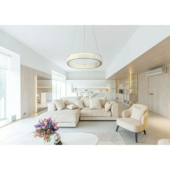 Globo Mucky LED-Pendelleuchte rund - 50 W, Ø x H: 50 x 120 cm, Klar, Silber verchromt - Ein helles Wohnzimmer mit einem runden, modernen Kronleuchter über einer beigen Couch. Der Kronleuchter ist ein echter Hingucker.