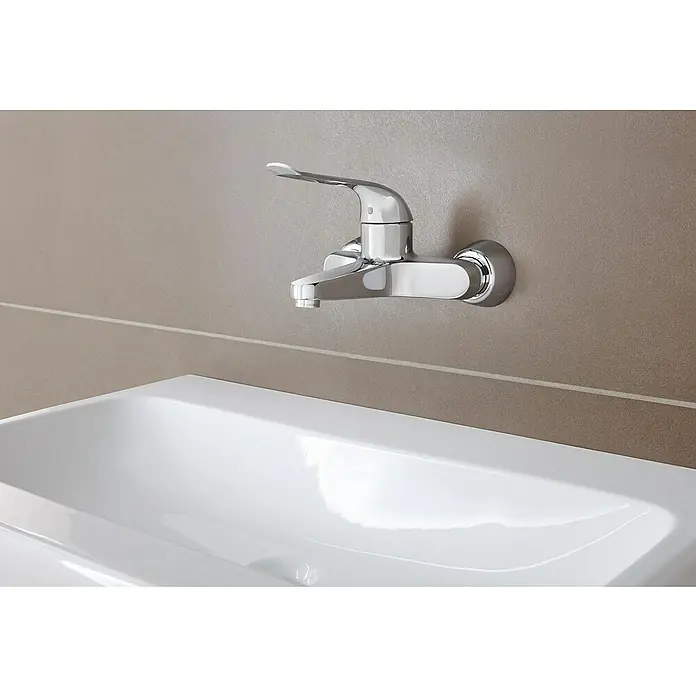 Grohe Euroeco Special Waschtischarmatur - Wandmontage, Chrom, Glänzend, Ausladung Armatur: 204 mm, Mit Einhandbedienhebel - Nahaufnahme einer glänzenden Armatur über einem weißen Waschbecken, die modernes Baddesign zeigt. Die Armatur sticht auf dem getönten Hintergrund hervor.