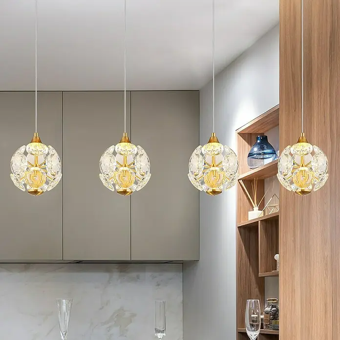 Globo Virina LED-Pendelleuchte - 32 W, L x B x H: 93 x 15 x 150 cm, Klar, Gold - Nahaufnahme von vier modernen Kristall-Pendelleuchten, die ein warmes Licht in einem stilvollen Raum verbreiten.