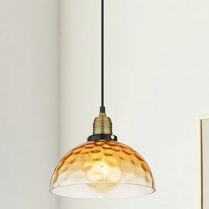 Globo Salvy Pendelleuchte - 60 W, Ø x H: 25 x 120 cm, Amber, Schwarz matt - Nahaufnahme einer goldenen Hängelampe mit gehämmertem Glasschirm und warmem Licht, die eine gemütliche Atmosphäre schafft.