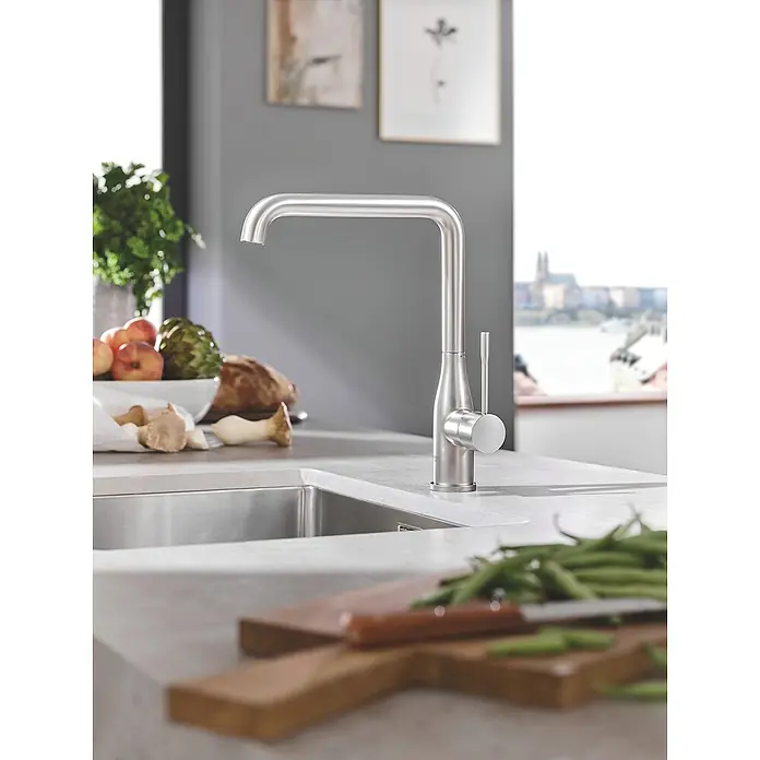 Grohe Essence Spültischarmatur - U-Auslauf, Supersteel, Matt - Nahaufnahme einer modernen Edelstahl-Küchenarmatur auf einer Küchenarbeitsplatte mit frischen Zutaten.
