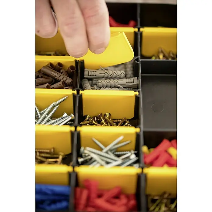 Stanley Kleinteilekoffer - Anzahl Fächer: 17 Stk., Ohne Inhalt, Schwarz/Gelb - Sortierbox mit Schrauben und Dübeln in verschiedenen Größen und Farben. Ein Finger öffnet ein gelbes Fach.