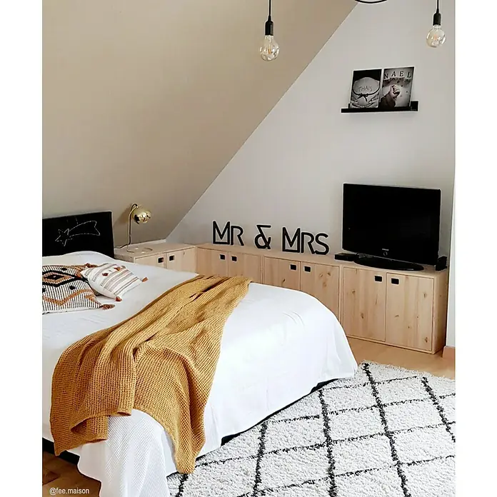 Astigarraga Dinamic Holz-Mehrzweckschrank - L x B x H: 33 x 70,8 x 105,4 cm, Holz - Schlafzimmer mit hellem Teppich, großem Bett mit senfgelbem Überwurf und minimalistischer Deko.