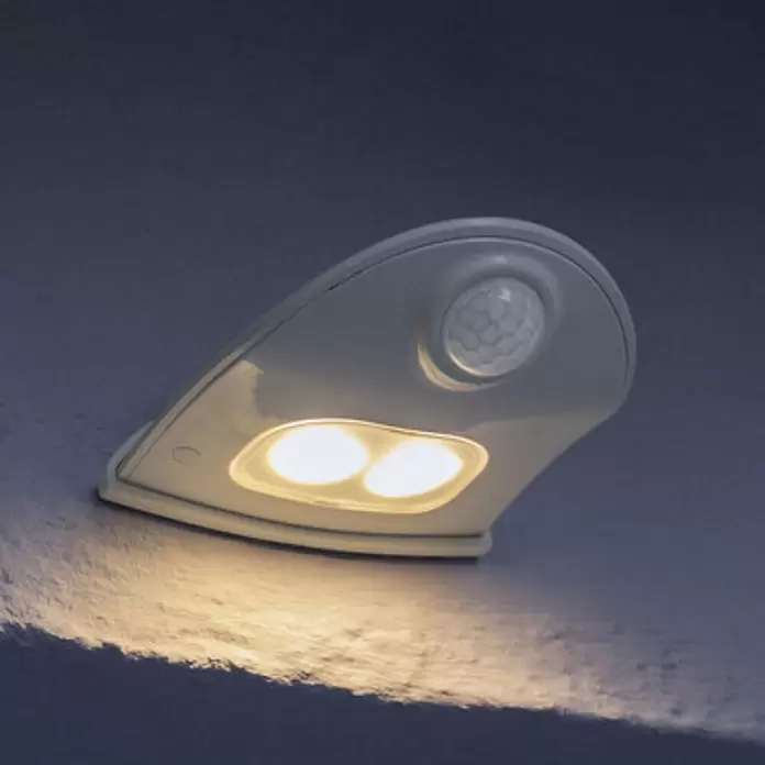 Ledvance LED-Türlicht Down - Weiß, Batteriebetrieben, 102,5 x 92,4 x 36,5 mm - Weißes Solar-LED-Wandlicht mit Bewegungssensor, das warmes Licht auf eine dunkle Fläche wirft.
