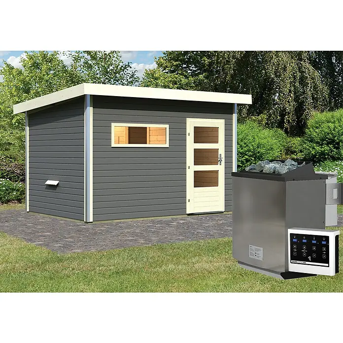 Karibu Saunahaus Danga - 9 kW Bio-Saunaofen mit externer Steuerung, Terragrau, L x B x H: 231 x 336 x 227 cm - Das Bild zeigt eine Außensauna mit Ofen und Steuerung auf einer Rasenfläche. Die Sauna hat ein Pultdach und eine helle Tür.