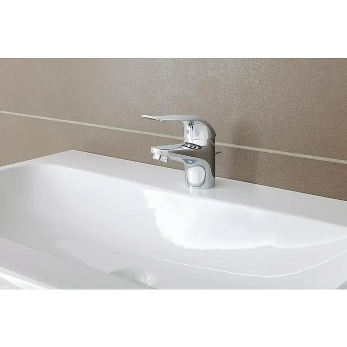 Grohe Euroeco Special Waschtischarmatur - Chrom, Glänzend - Nahaufnahme eines modernen Chrom-Wasserhahns auf einem glänzenden weißen Waschbecken mit braunem Hintergrund, der ein elegantes Badezimmerdesign zeigt.