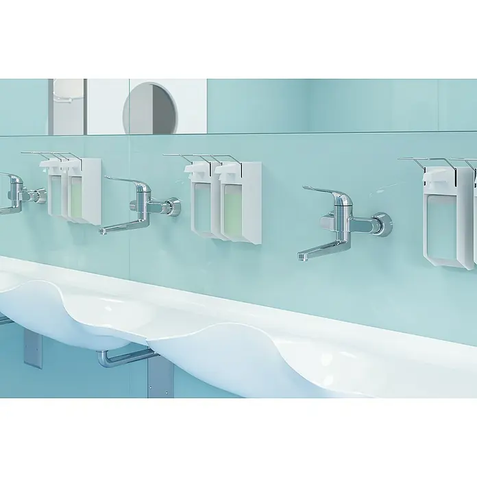 Grohe Euroeco Special Waschtischarmatur - Wandmontage, Chrom, Glänzend, Ausladung Armatur: 341 mm - Eine helle Toilette mit einer langen weißen Spüle, Armaturen und Seifenspendern, die an einer hellblauen Wand befestigt sind.