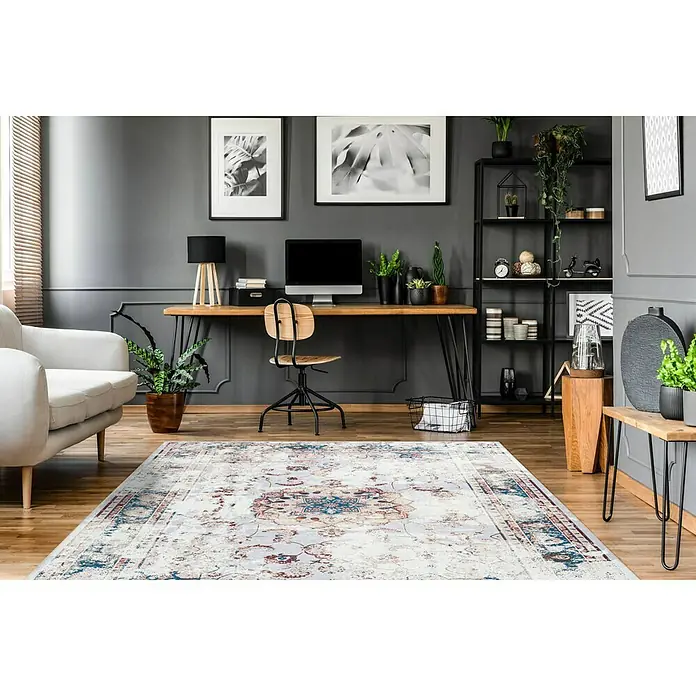 Kayoom Flachgewebeteppich Galaxy - Multi/Blau, 180 x 120 cm, 100 % Polyester - Einrichtungsszene mit einem gemusterten Teppich, einem Schreibtisch und einem Sofa, die eine elegante und gemütliche Arbeitsatmosphäre schafft.